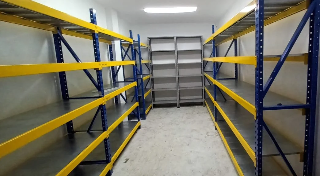 Montaje de estantería metálica industrial B2B en amplio cuarto de almacenamiento